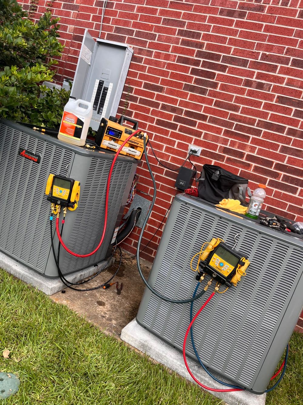 HVAC units with tools and equipment for maintenance outside a brick building.